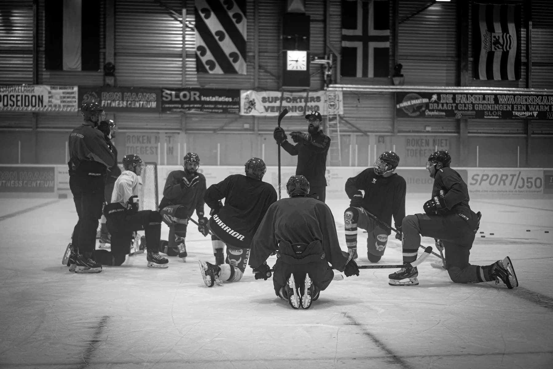 A coach gives instructions to an ice hockey team
